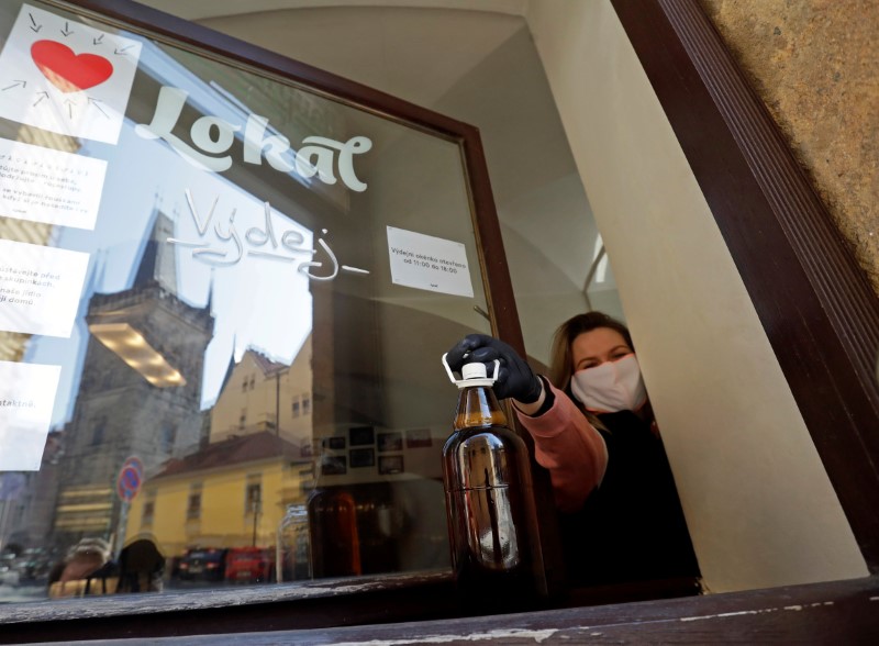 A bartender prepares plastic bottles inside of a closed pub in Prague