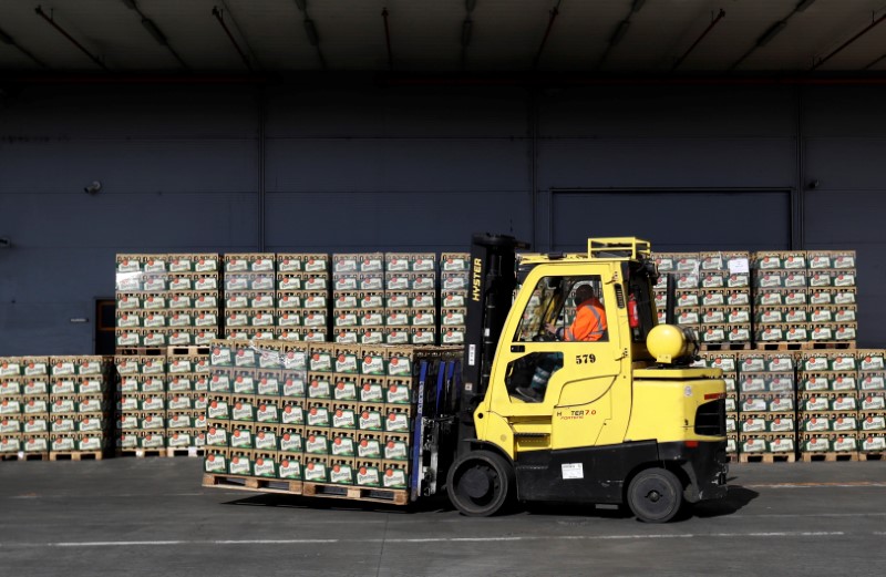 Workers walk past crates of beer on the yard of Plzensky Prazdroj brewery in Plzen