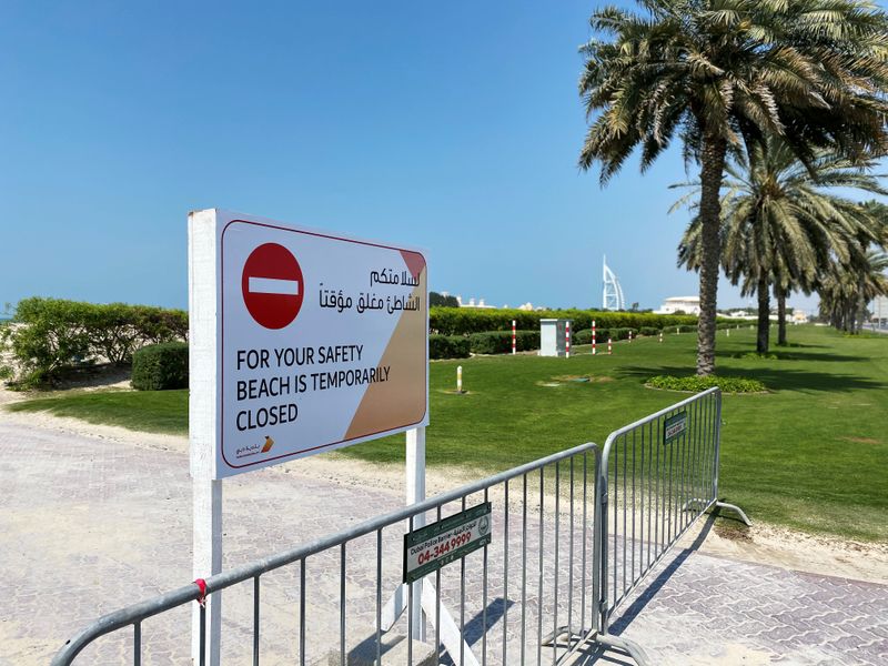 A sign board is seen at the entrance of an empty beach, after a curfew was imposed to prevent