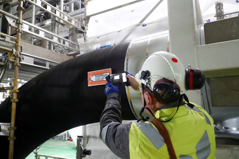 FILE PHOTO: A man takes a picture of the oil pipe on the Equinor's Johan Sverdrup oilfield