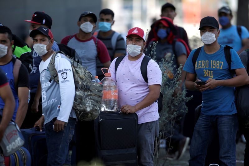 FILE PHOTO: Migrants seeking for a U.S. work visa after being evicted from hotel, which local