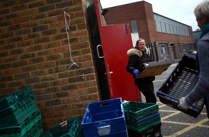 Dionne Tracey carries a crate of food items to be delivered to local residents from the