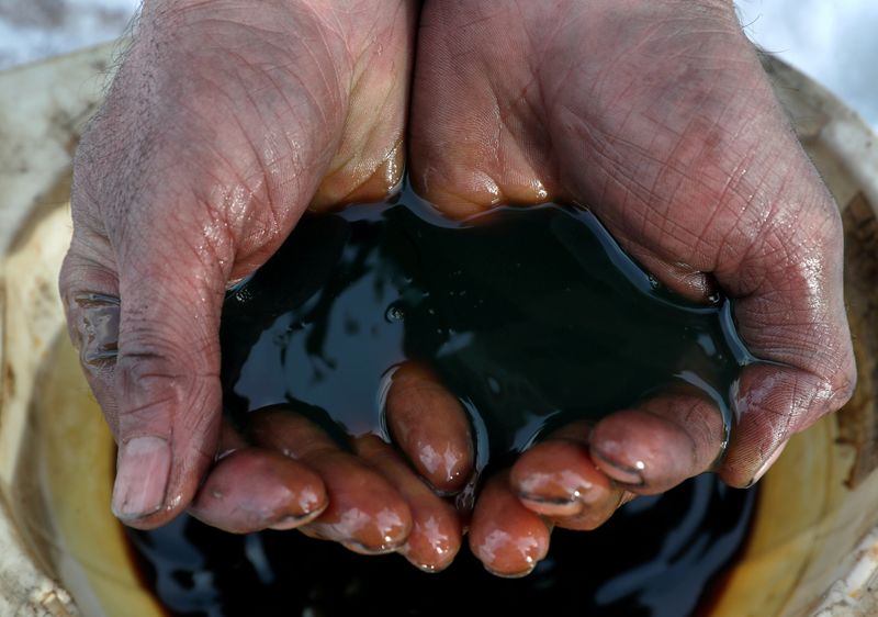 An employee holds a sample of crude oil at the Irkutsk Oil Co-owned Yarakta field in the
