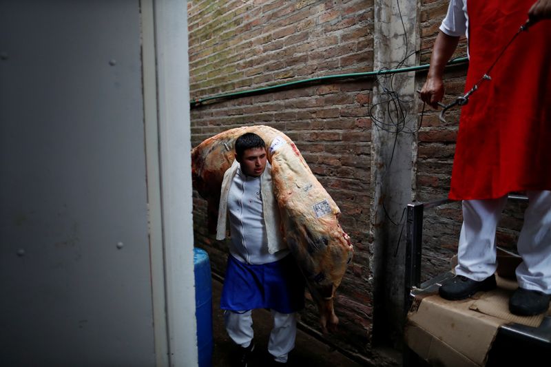 A butcher stores a cattle carcassin a butcher shop during the coronavirus disease (COVID-19),