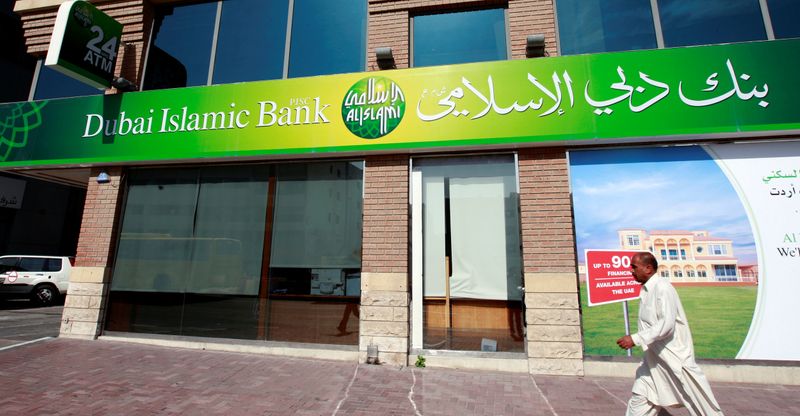 FILE PHOTO: A man walks past a branch of Dubai Islamic Bank branch along Khalid Bin Al-Waleed