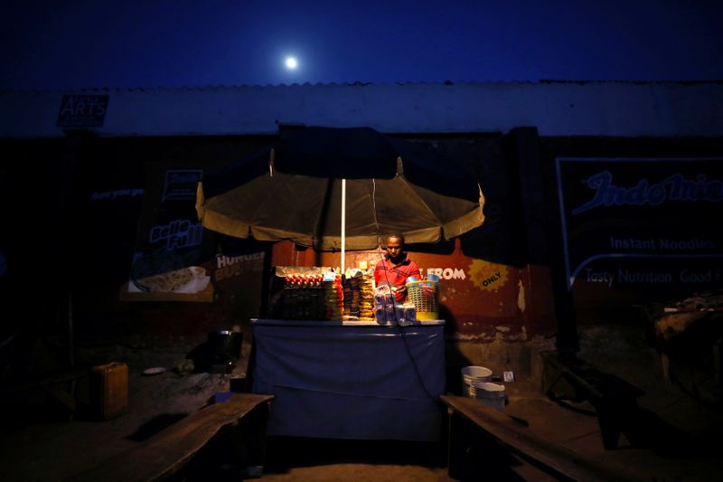 Kemi Adepoju, a dressmaker, folds a material in her shop amid the spread of the coronavirus