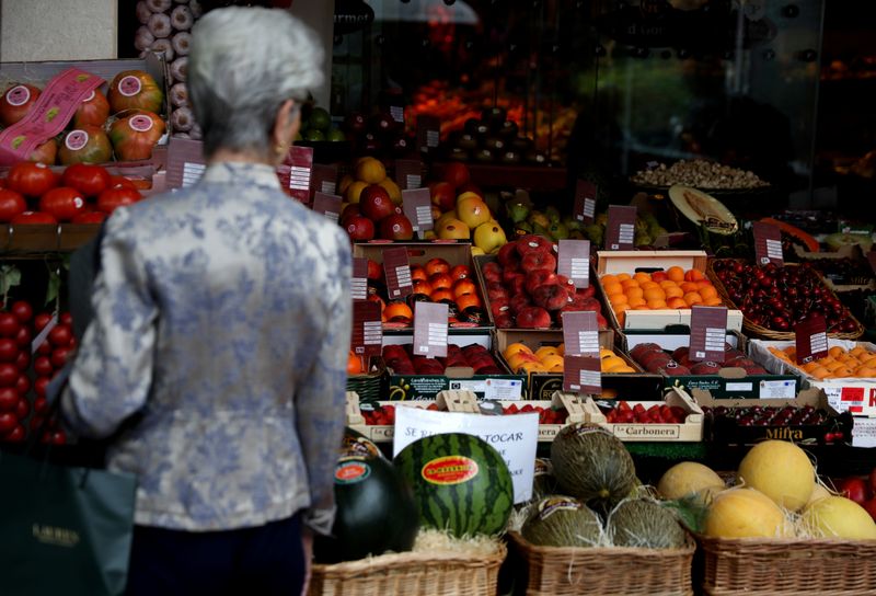 FILE PHOTO: A woman looks at fruits on display outside a greengrocery in Madrid