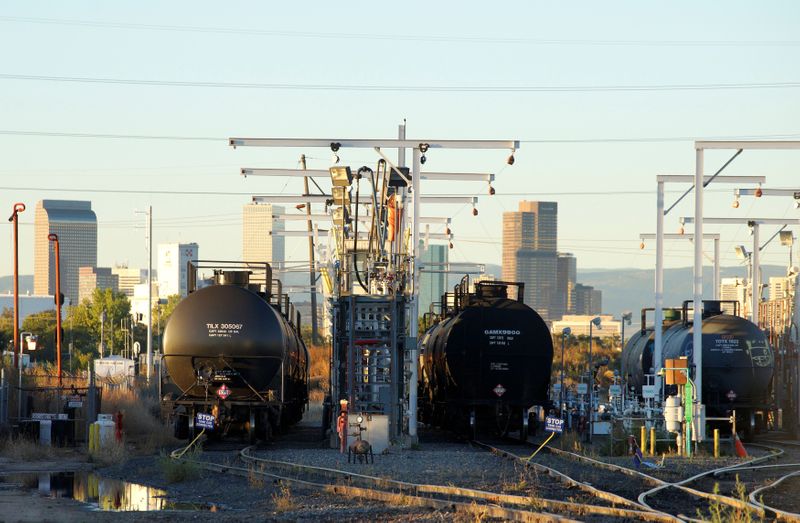 FILE PHOTO: Oil tanker railcars are parked at a filling rack at sunrise with the Denver