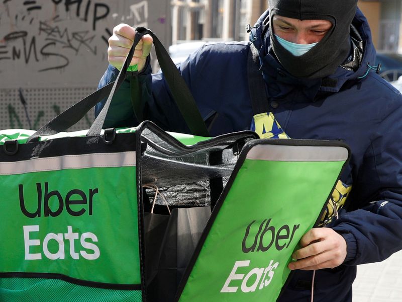 FILE PHOTO: An Uber Eats food delivery courier closes a bag with an order in central Kiev