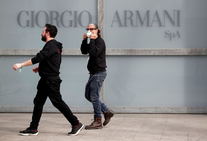 FILE PHOTO: Workers walk past the Giorgio Armani logo outside the theatre where the Italian