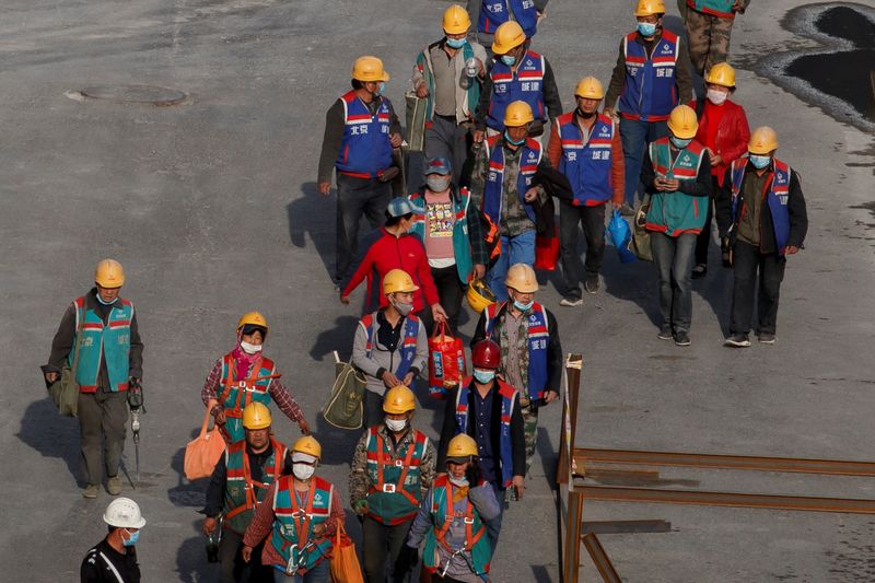 Workers leave a construction site at the end of their shift in the Central Business District in