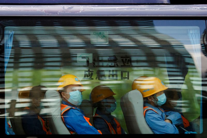 Workers leave a construction site at the end of their shift in the Central Business District in