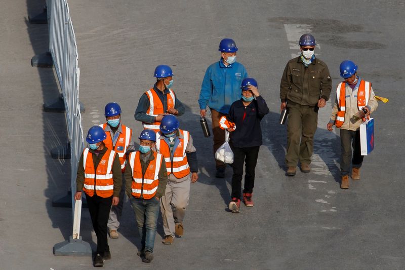 Workers leave a construction site at the end of their shift in the Central Business District in