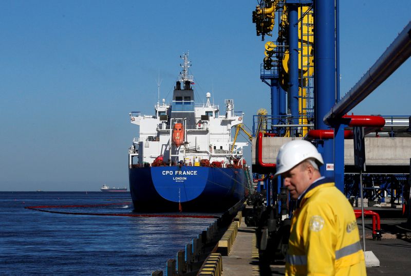 FILE PHOTO: Oil is pumped into an oil tanker at the Ust-Luga oil products terminal in the