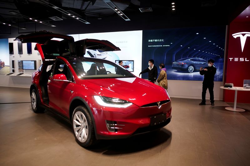 FILE PHOTO: People wearing face masks are seen inside a Tesla showroom at a shopping mall in
