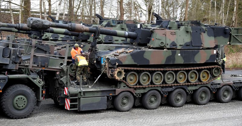 FILE PHOTO: Soldiers of German Army Bundeswehr load a U.S. M109 tank onto a heavy goods