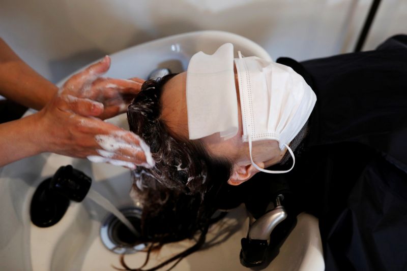 A waitress checks the temperature of a customer at Toshirhin restaurant in Tokyo