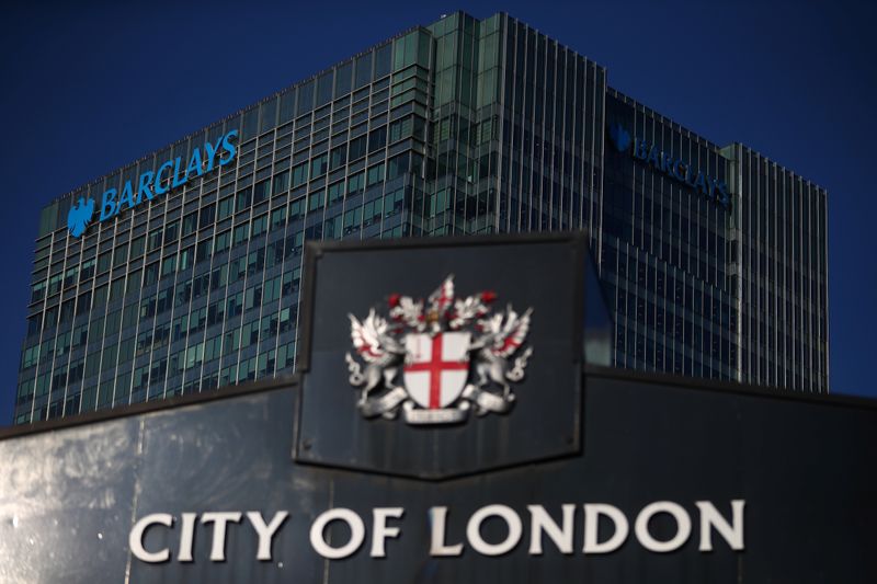 FILE PHOTO: Barclays' building in Canary Wharf is seen behind a City of London sign outside