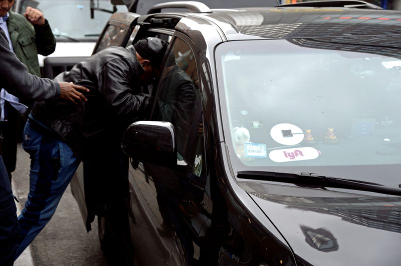 FILE PHOTO: A passenger enters an Uber car in New York City