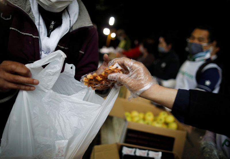 An elderly man receives food aid handouts, as the spread of the coronavirus disease (COVID-19)