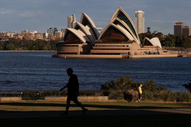 FILE PHOTO: People stroll through a park in front of the Sydney Opera House in Sydney