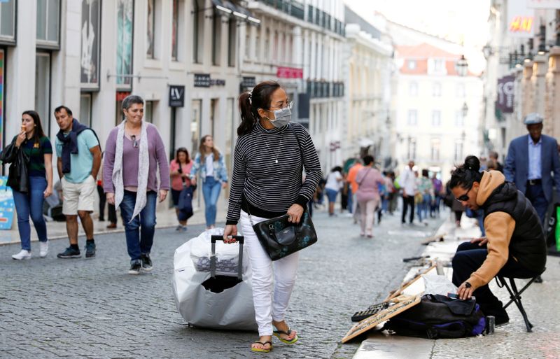 FILE PHOTO: A tourist wearing a protective face mask, due to the coronavirus outbreak, walks in