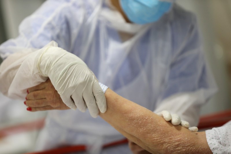 FILE PHOTO: A healthcare worker treats an elderly patient at the emergency room as the spread