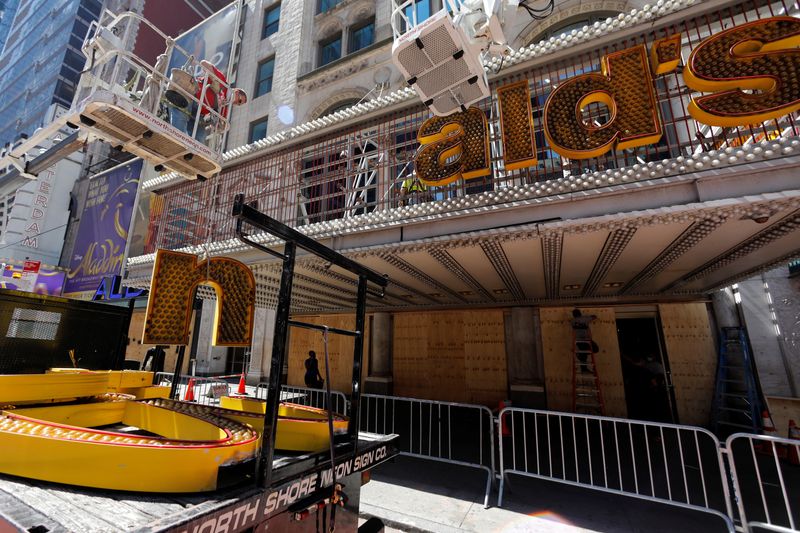 Workers remove a sign from a permanently closed McDonald's restaurant in Times Square in New