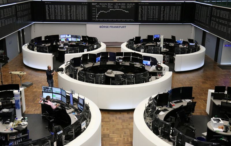 A worker shelters from the rain as he passes the London Stock Exchange in London