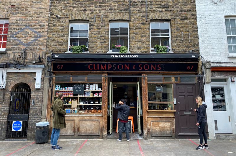 FILE PHOTO: People observe social distancing rules outside Climpson & Sons coffee shop in