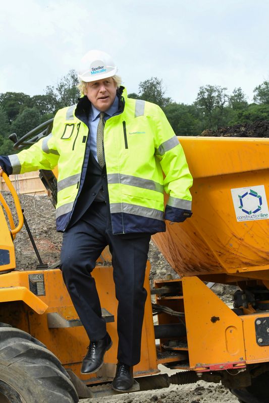 Britain's Prime Minister Boris Johnson gestures as he speaks with construction apprentices at