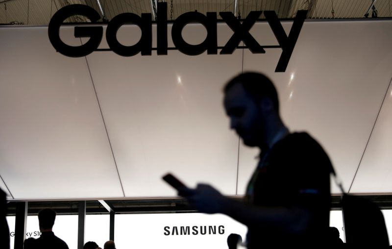 FILE PHOTO: A visitor uses a mobile phone at the Samsung booth at the Mobile World Congress in